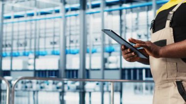 Akıllı fabrika uzmanı otomatik sistemleri test etmek ve güvenilirliği sağlamak için dijital cihaz uygulaması kullanıyor. İşçi, dar boğazları tanımlamak için tablet kullanır ve sensör verilerine ve kamera görüntülerine dayanarak ekipmanları optimize eder.