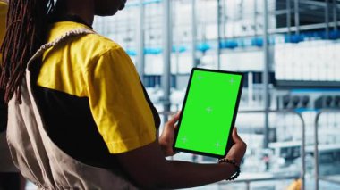 Akıllı fabrika uzmanı izole ekran tableti kullanarak robotik kolları yönetiyor. Kapatın. Endüstri 4.0 endüstriyel fabrika çalışanı otomatik makineleri krom anahtar cihazı kullanarak kontrol ediyor, kamera A