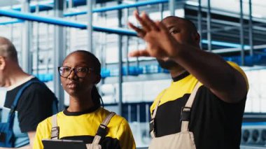 Akıllı fabrika çalışanları konuşuyor, otomatik sistemleri test etmek için birlikte çalışıyorlar. Endüstri 4.0 Endüstriyel Sanayi İş Arkadaşları Dar geçitleri tanımladı ve veriye göre donanımı optimize etti, kamera A