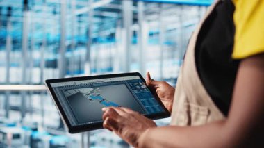 Endüstri 4.0 sanayi mühendisi, tablet üzerinde CAD yazılımı kullanan yeni robotik makineler tasarlıyor. Akıllı fabrika teknisyeni, dijital aygıt uygulamasını kullanarak otomasyon ekipmanları için, kamera A 'yı kullanıyor.