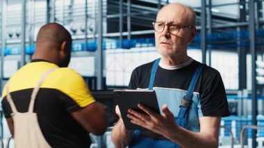 Endüstriyel fabrika kıdemli mühendisi sektör 4.0 otomatik iş akışı ve kontrol sistemlerini uygulayarak işlemleri bilgisayara geçiriyor. Yaşlı uzman sensörleri üretime entegre ediyor. Kamera. Yakın plan.