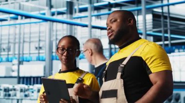 PV materyallerini araştırmak için tablet kullanan akıllı fabrika çalışanları. Endüstri 4.0 güneş panelleri Afro-Amerikan mühendisleri alternatif enerji sistemleri prototipleri geliştiriyor, kamera A