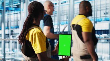 Akıllı fabrika uzmanı izole ekran tableti kullanarak robotik kolları yönetiyor. Kapatın. Endüstri 4.0 endüstriyel fabrika çalışanı otomatik makineleri krom anahtar cihazı kullanarak kontrol ediyor, kamera A