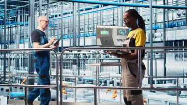 Sistem performans ölçümlerine bakan akıllı fotovoltaik fabrikasındaki mutlu mühendisin portresi. Güneş panellerindeki neşeli işçi IoT sensörleri ve kamera A 'dan enerji üretimini takip ediyor.