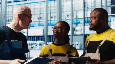 Photovoltaics akıllı fabrika kıdemli mühendisi gerekli ayarlamaları not alıyor, iş arkadaşlarıyla konuşuyor. Endüstri 4.0 güneş panelleri fabrika ekip lideri üretim planlarını değiştiriyor, kamera A