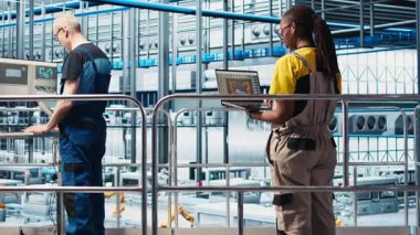 Fotovoltaik 'teki teknisyen. Akıllı fabrika. Laptop kullanarak veri analiz ediyor. Sektör 4.0 güneş panelleri uzmanı yenilenebilir enerji üreten tesis sistem ölçümlerini gözden geçirmek için defter kullanıyor, kamera A