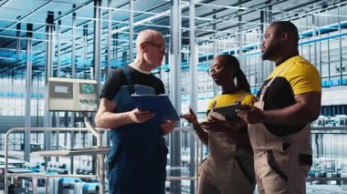 Sanayi 4.0 fotovoltaik tesisi kıdemli mühendis, işçilerle güç üretimini en üst seviyeye çıkarmak için evrak görüşmeleri yapıyor. Güneş panelleri akıllı fabrika tecrübeli liderleri teknisyenlere ve kamera A 'ya görev veriyor.