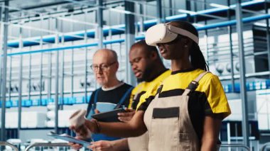 VR kulaklık takan akıllı fotovoltaik fabrikası uzmanı sistem performans ölçümlerine bakıyor. Güneş panelleri fabrika işçisi sanal gerçeklik teknolojisini IoT sensörleri ve kamera A aracılığıyla enerji üretimini takip etmek için kullanır.