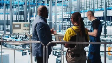 Mühendisler, sistem performansına bakarak akıllı fotovoltaik fabrikasını denetleyen yöneticilerle konuşuyor. İşçiler güneş panellerinden geri bildirim alıyorlar fabrika denetçisi, enerji üretimini takip eden, kamera A