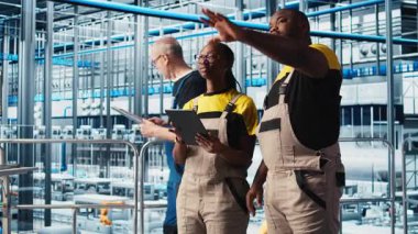 Akıllı fabrika çalışanları konuşuyor, otomatik sistemleri test etmek için birlikte çalışıyorlar. Endüstri 4.0 Endüstriyel Sanayi İş Arkadaşları Dar geçitleri tanımladı ve veriye göre donanımı optimize etti, kamera A