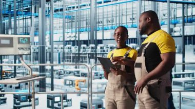 PV materyallerini araştırmak için tablet kullanan akıllı fabrika çalışanları. Endüstri 4.0 güneş panelleri Afro-Amerikan mühendisleri alternatif enerji sistemleri prototipleri geliştiriyor, kamera A