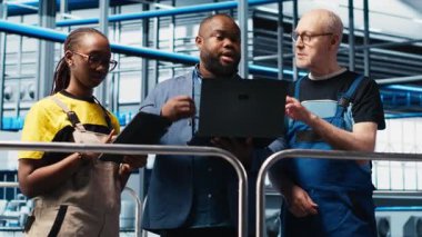 Akıllı fabrika müdürü, çalışanlarla otomatik iş akışı uygulamasını tartışıyor. İşçilerle yapılan sanayi fabrikası görüşmelerini denetleyen, sensörleri üretime entegre eden, kamera A