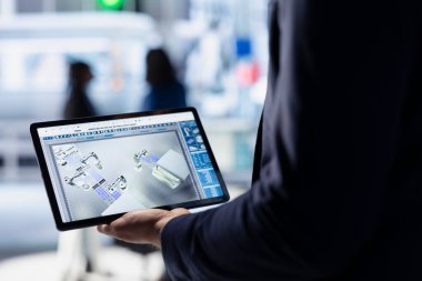 Güneş paneli tesisindeki teknisyen tabletteki fotovoltaik sistem performansını inceliyor. Endüstriyel santraldeki verimliliği optimize etmek için cihaz üzerindeki üretim ölçümlerini analiz eden uzmanlığı kapat