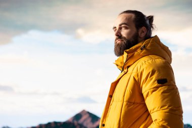 Kararlı gezgin, gökyüzünün enginliği ve engebeli zirvelerden esinlenerek destansı dağ sırasına ve manzaraya bakıyor. Yürüyüş yaparken büyük açık havayı kucaklamanın ödülü..