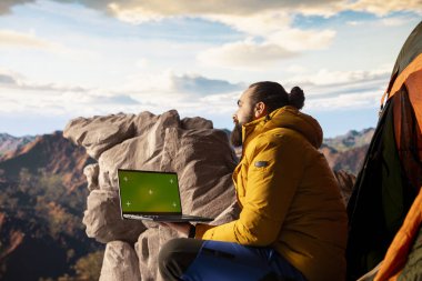 Genç gezgin, krom anahtarın yanındaki yüksek rakımlı yabanı, temiz hava ve manzaralı dağ manzarasının yürüyüş ve macera için ilham verici bir ortam sağladığı bir cihaz kullanarak kucaklıyor..