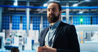Fotovoltaik fabrikasındaki adam sürdürülebilir enerji üretimiyle ilgili promosyon videoları çekiyor. Güneş panelleri imalat uzmanı, güneş pilleri üretim sürecini seyircilere açıkladı, kamera B