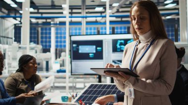 Happy araştırmacı güneş pili prototiplerini enerji üretimini optimize etmek için tablet kullanarak analiz ediyor. Neşeli güneş panelleri bitki uzmanı cihaz, kamera A kullanarak yenilikçi üretim teknolojisi geliştiriyor.