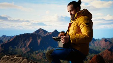 Fotoğrafçı, insansız hava aracıyla dağın tepesinde profesyonel içeriği kaydediyor, vahşi doğada yürüyüş yapıyor ve manzaralı manzara görüntülerini yakalıyor. Vahşi doğanın hava fotoğrafçılığı. Kamera A.