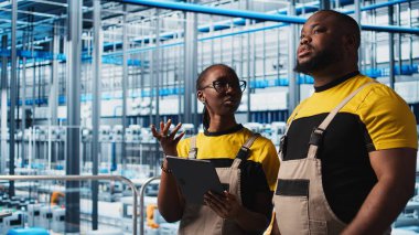 Akıllı fabrika çalışanları konuşuyor, otomatik sistemleri test etmek için birlikte çalışıyorlar. Endüstri 4.0 Endüstriyel Sanayi İş Arkadaşları Dar geçitleri tanımladı ve veriye göre donanımı optimize etti, kamera A