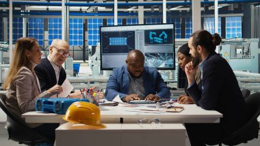 Fabrika mühendislik ekibi üretim hatlarına bakıyor, enerji üretimini arttırmak için çalışıyorlar. Fotovoltaik uzmanları yenilikçi güneş pili prototipleri üzerinde kafa yoruyor, şemaları inceliyor, kamera A