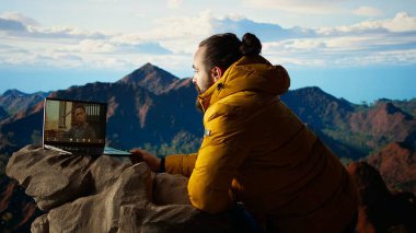 Genç CEO dağın tepesinden gelen bir video çağrısına güçlü bir sinyalle giriyor, her zaman iş bağlantıları ile bağlantılılar ve iş konuları hakkında tartışıyorlar. İşkolik bir adam yürüyüş yapıyor. Kamera A.