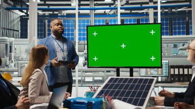 Fabrika hissedarları yeşil ekran monitörüne bakarak şirket büyümesinden bahsediyorlar. Yatırımcılar üretimi geliştirmek için fabrika yöneticileriyle bir araya geliyor, sunuma bakıyorlar, kamera A