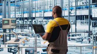Fotovoltaik akıllı fabrika teknisyeni bilgisayar yazılımı kullanarak hasarlı IoT sensörlerini tamir ediyor. Endüstri 4.0 güneş panelleri, dizüstü bilgisayarı kullanarak bitki uzmanı hata bulun ve çalışma süresini azaltın, kamera A