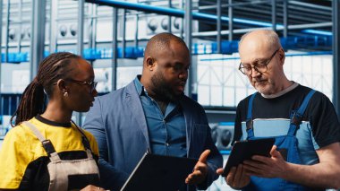 Endüstri 4.0 güneş panelleri mühendislerinin çalışma süresinin azaltılması için yaptıkları çalışmaları denetleyen kişi. Fotovoltaik zeki fabrika yöneticisi işçilere hasar gören IOT sensörlerini, kamera A 'yı tamir etme görevi veriyor.