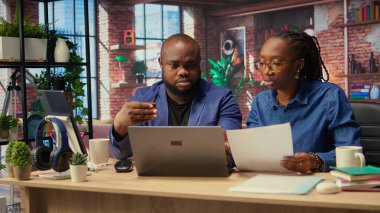 Evlerindeki Afrikalı Amerikalılar hesap aboneliğini yenilemek ve dizüstü bilgisayardaki yayın hizmetlerini yönetmek için kart numaralarını giriyorlar. Çift para aktarıyor, kimlik bilgilerini güncelliyor. Kamera A.