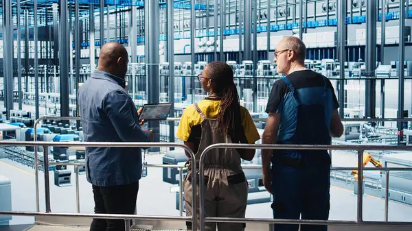 Sektör 4.0 endüstriyel santrali denetleyen yönetici CAD yazılımı kullanarak makine dizayn eden işçilere talimatlar veriyor. Akıllı fabrika yöneticisi mühendislere otomasyon ekipmanı ve kamera A 'yı geliştirme görevi veriyor.