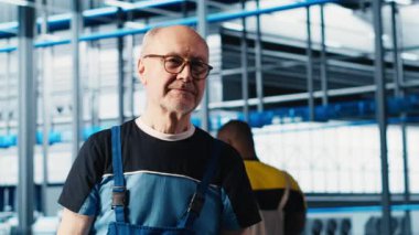 Endüstri 4.0 endüstriyel fabrika kurma makinelerinin üst düzey mühendisinin portresi eksiksiz testler yapıyor. Akıllı fabrikada IoT sensörlerini ayarlayan neşeli yaşlı adam.