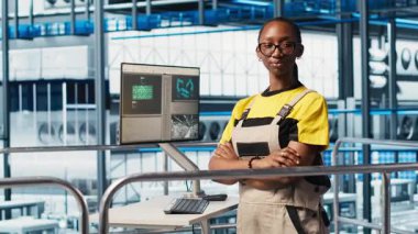 Üretkenliği arttırmak için öngörü algoritmaları üzerinde çalışan mutlu akıllı fabrika mühendisinin portresi. Neşeli endüstri 4.0 fabrika teknisyeni, tesisin zeminini denetliyor.