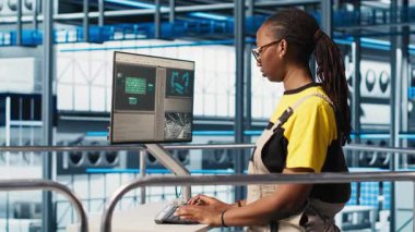 PV materyallerini araştırmak için bilgisayarda yazan neşeli fotovoltaik akıllı fabrika mühendisinin portresi. Endüstrideki neşeli kadın 4.0 güneş paneli bitkisi yeşil enerji sistemleri prototipleri geliştiriyor, kamera A