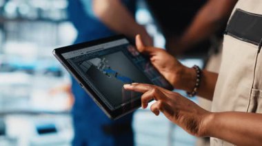 Endüstri 4.0 sanayi mühendisi, tablet üzerinde CAD yazılımı kullanan yeni robotik makineler tasarlıyor. Akıllı fabrika teknisyeni, dijital aygıt uygulamasını kullanarak otomasyon ekipmanları için, kamera A 'yı kullanıyor.