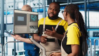 Akıllı fabrikadaki sistem yöneticileri veri toplayıp analiz ediyorlar. İş arkadaşları beyin fırtınası yapıyor, endüstriyel tesiste takip yazılımı kullanıyor gelişmiş sensörler ve kamera ile donatılmış.