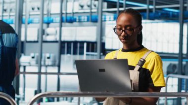 Akıllı fabrika mühendisi tesis zeminindeki robotik silah ve taşıma sistemlerini denetliyor. Endüstri 4.0 fabrika teknisyeni sistem performansını izliyor ve sorun giderme sorunları, kamera A