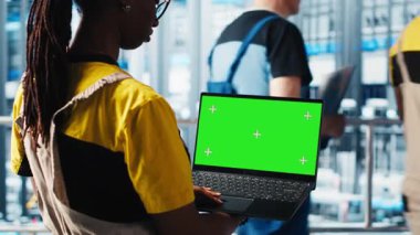 Akıllı fabrika uzmanı otomatik sistemleri test etmek ve güvenilirliği sağlamak için model dizüstü bilgisayar kullanıyor. Kadın darboğazları tanımlamak ve ekipmanları optimize etmek için izole ekran defteri kullanır, kamera A