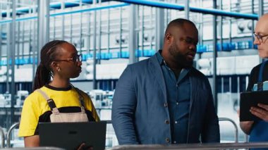 Endüstri 4.0 endüstriyel fabrika montaj makinelerinde mühendislik ekibi tarafından yapılan denetleme çalışmaları. IoT sensörlerini ayarlamak için beyin fırtınası yapan zeki fabrika çalışanlarını denetleyen denetleyici.