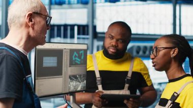 Deneyimli takım lideri, 4.0 fotovoltaik fabrikasında yeni öğrencilere indüksiyon yapıyor. Akıllı güneş panelleri fabrikasında kıdemli mühendis stajyerlere güç üretimini arttırmayı öğretiyor, kamera A