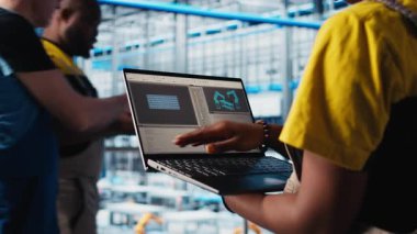 Güneş panelleri, dizüstü bilgisayardaki IoT sensörlerinden enerji üretimini takip eden fabrika işçisi. Akıllı fotovoltaik fabrikasındaki mühendis dizüstü bilgisayar ve kamera performans ölçümlerine bakıyor.