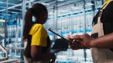 Akıllı fabrika uzmanı otomatik sistemleri test etmek ve güvenilirliği sağlamak için dijital cihaz uygulaması kullanıyor. İşçi, dar boğazları tanımlamak için tablet kullanır ve sensör verilerine ve kamera görüntülerine dayanarak ekipmanları optimize eder.