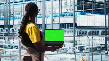 Akıllı fabrika profesyoneli, izole ekran dizüstü bilgisayar kullanarak otomatik iş akışları gerçekleştirir, elle işlemleri dijitalleştirir. Kadın sensörleri modelleme defteri ve kamera A ile üretime sokuyor.