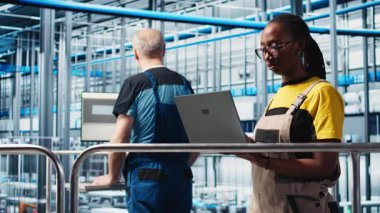 Akıllı fabrika mühendisi tesis zeminindeki robotik silah ve taşıma sistemlerini denetliyor. Endüstri 4.0 fabrika teknisyeni sistem performansını izliyor ve sorun giderme sorunları, kamera A