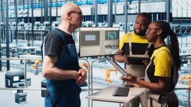 Deneyimli takım lideri, 4.0 fotovoltaik fabrikasında yeni öğrencilere indüksiyon yapıyor. Akıllı güneş panelleri fabrikasında kıdemli mühendis stajyerlere güç üretimini arttırmayı öğretiyor, kamera A