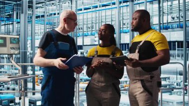 Photovoltaics akıllı fabrika kıdemli mühendisi gerekli ayarlamaları not alıyor, iş arkadaşlarıyla konuşuyor. Endüstri 4.0 güneş panelleri fabrika ekip lideri üretim planlarını değiştiriyor, kamera A