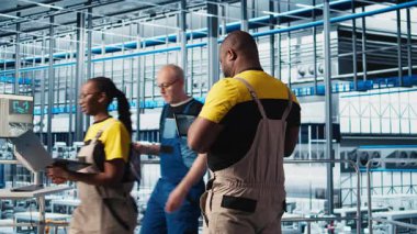 Endüstri 4.0 endüstriyel fabrika uzmanı tablet üzerindeki CAD programını kullanarak yeni robotik makineler tasarlıyor. Afrika kökenli Amerikalı bir adam akıllı fabrikada otomasyon ekipmanları için cihaz kullanıyor. Kamera A