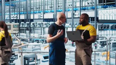 Akıllı fotovoltaik fabrikasındaki kıdemli mühendis stajerle konuşuyor, sistem performans ölçümlerini gösteriyor. Deneyimli güneş panelleri enerji üretimini takip eden yeni stajyer ve kamera A 'ya rehberlik ediyor.