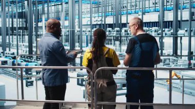 Sektör 4.0 endüstriyel santrali denetleyen yönetici CAD yazılımı kullanarak makine dizayn eden işçilere talimatlar veriyor. Akıllı fabrika yöneticisi mühendislere otomasyon ekipmanı ve kamera A 'yı geliştirme görevi veriyor.