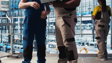 Akıllı fabrika kıdemli mühendisi yeni stajyere robotik silah kullanmayı öğretiyor. Endüstri 4.0 Endüstriyel Santral Takım Lideri ve stajyer otomatik makineleri kontrol ederek, iş akışının devamlılığını sağlıyor, kamera A