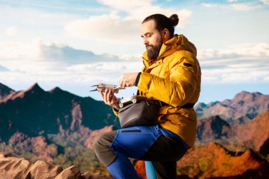 Modern gezgin, içerik yaratır ve dronuyla vadiyi filme çeker yüksek rakımlı bir dağ sırasının tepesine tırmanır. Manzaranın tadını çıkaran yürüyüşçü, uzaktan kumanda..
